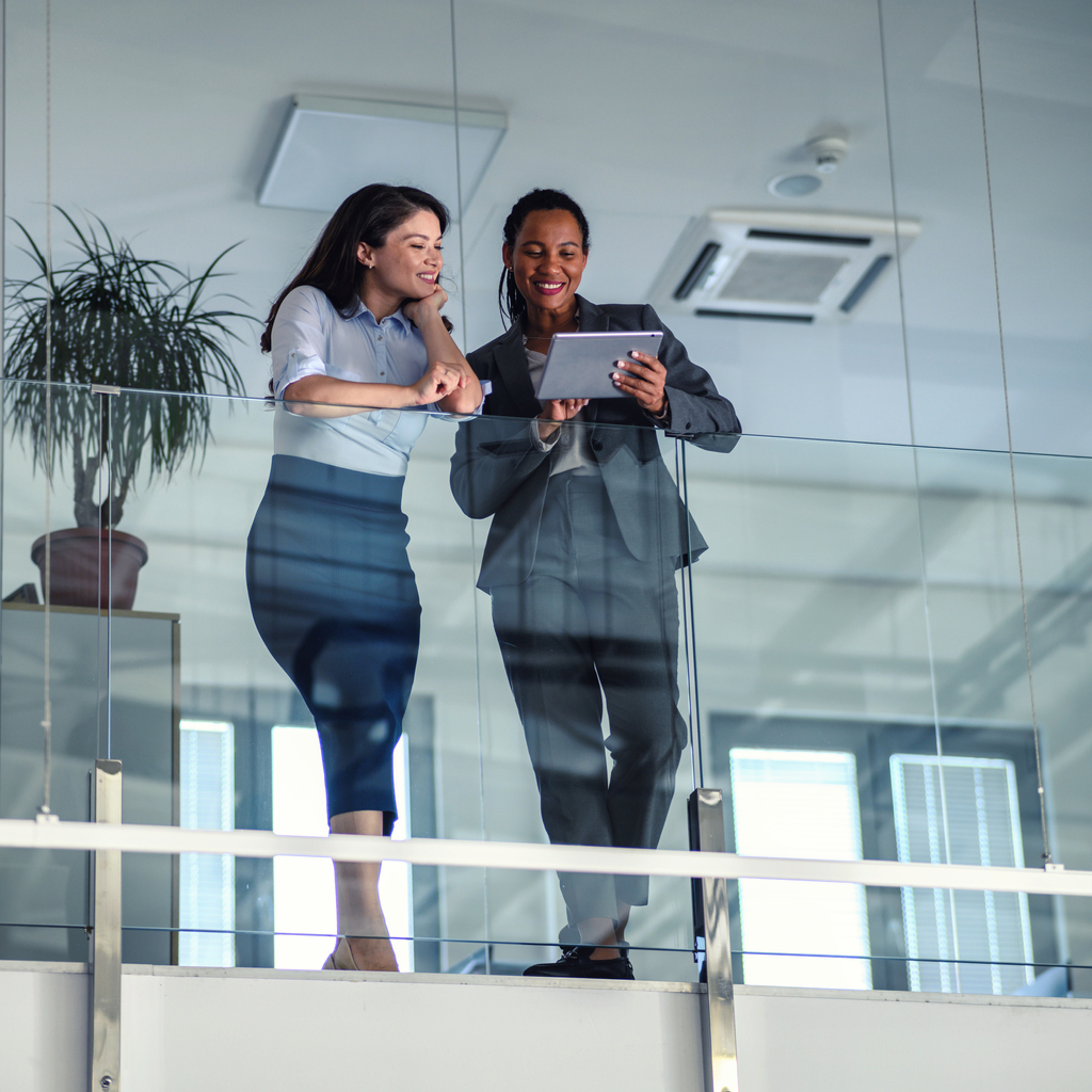 Two business people talking in an office building The Network Workplace Giving Australia