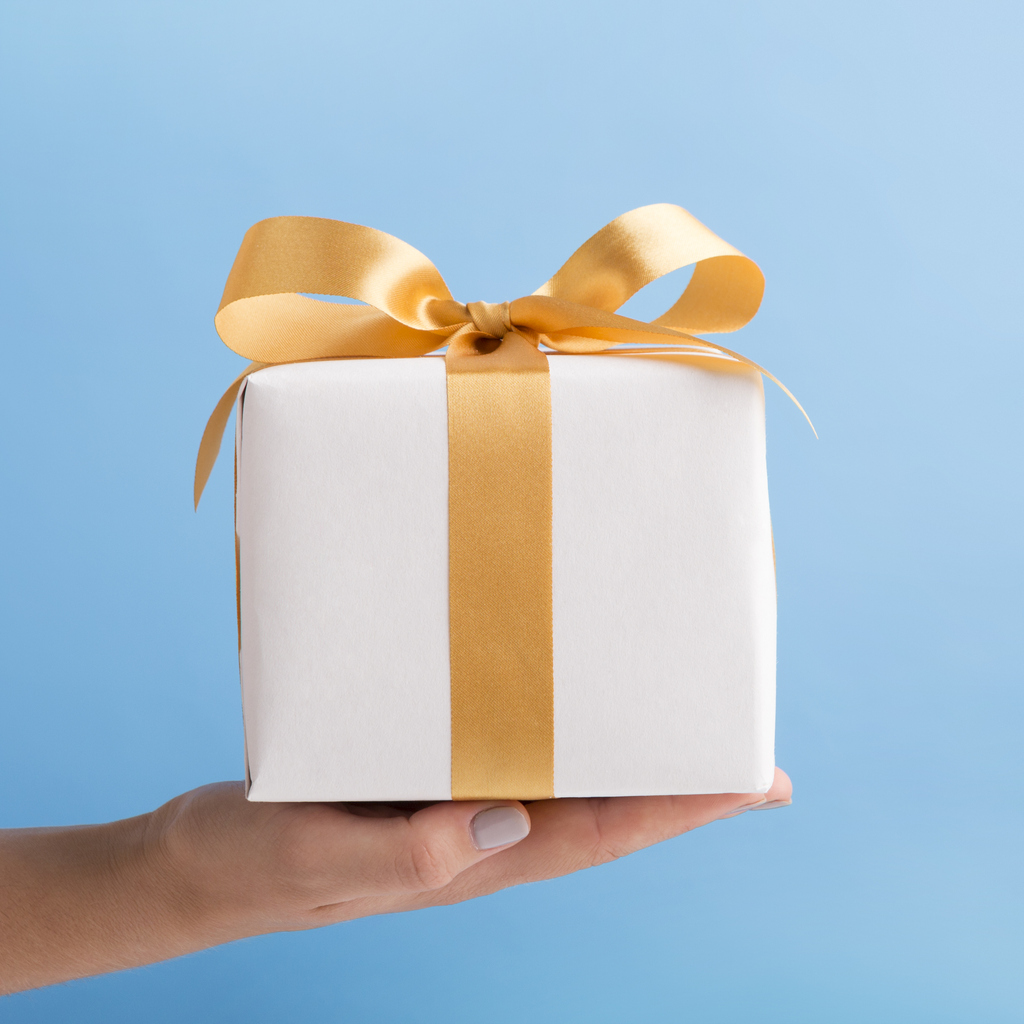 Wrapped cube present with gold bow workplace charity giving